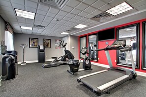 A gym with treadmills, elliptical machines, and weight equipment.