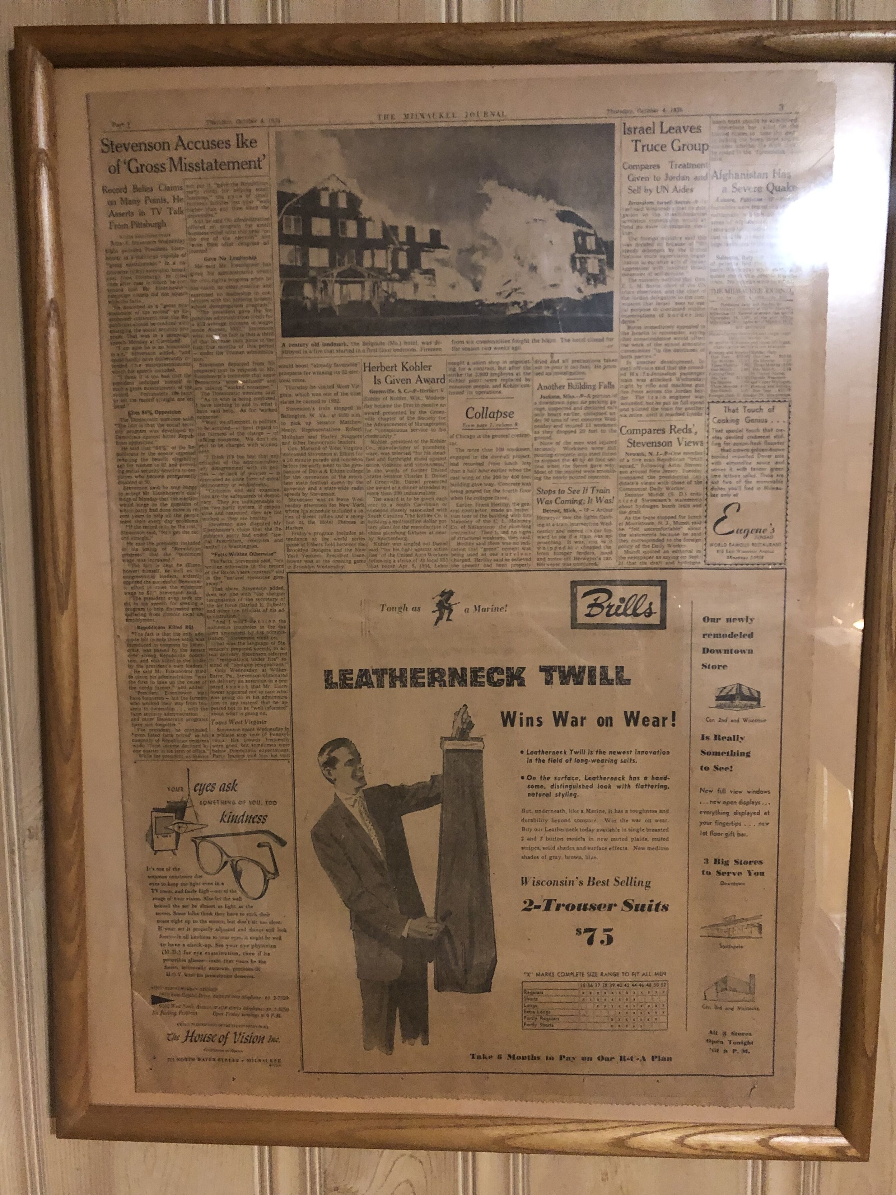 Een krantenartikel in een lijst met een opvallende advertentie voor 'LEATHERNECK TWILL', met een man in een pak.