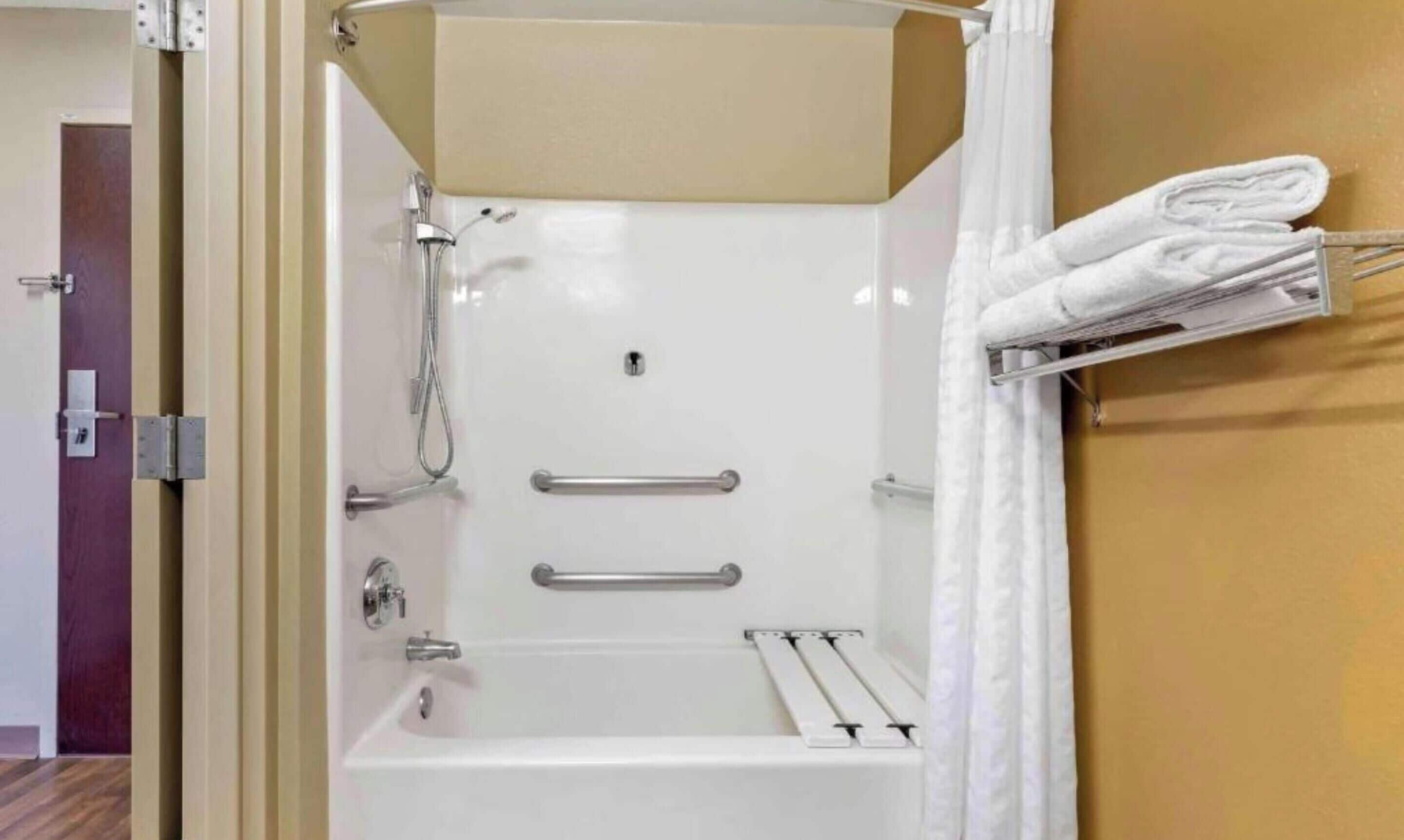 Un baño moderno con bañera, ducha y perchero para toallas.