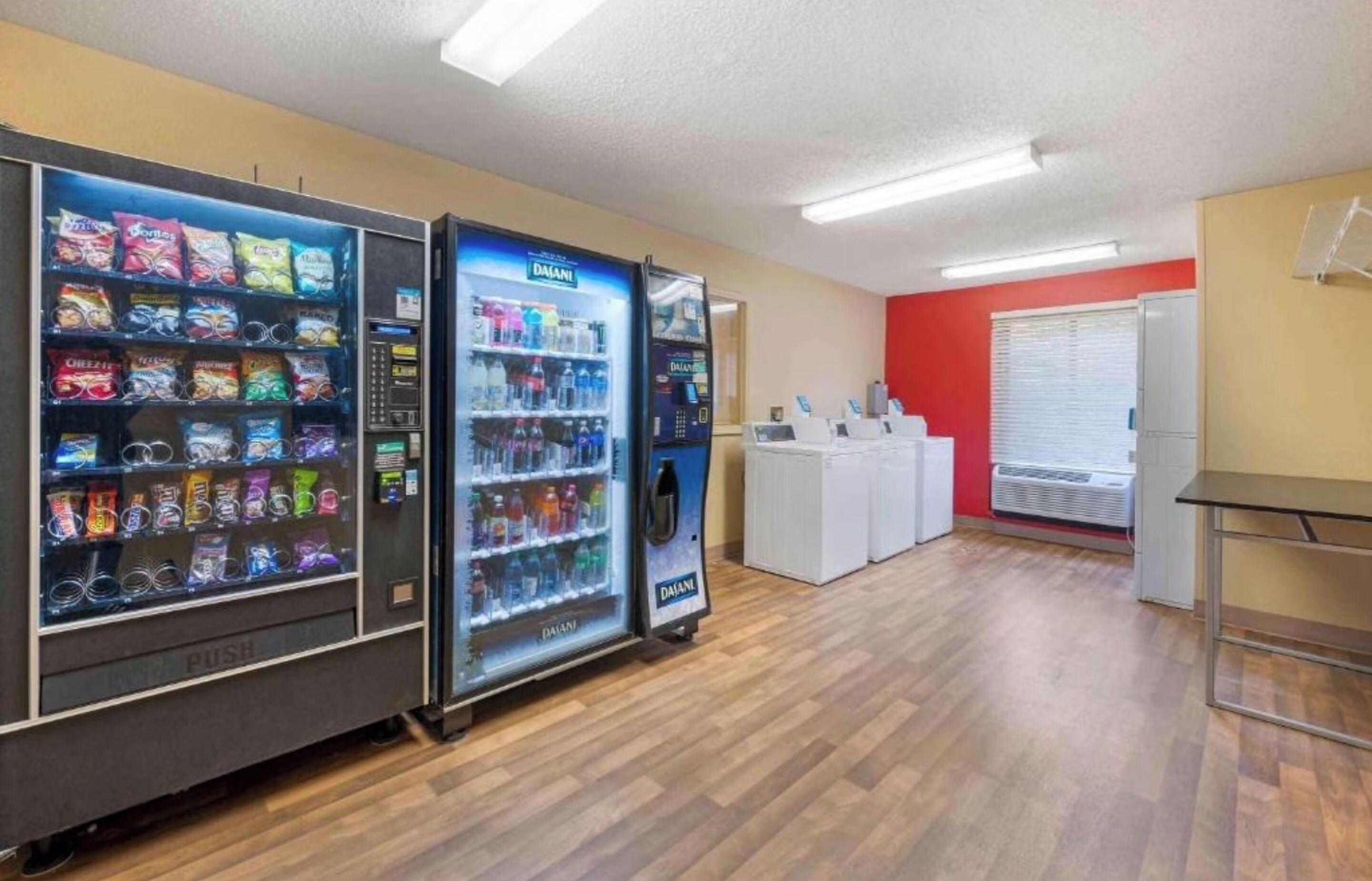 A room with vending machines, a white reception desk, and a red wall.