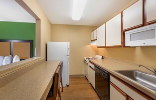 Una cocina funcional con refrigerador, estufa, lavavajillas y microondas.