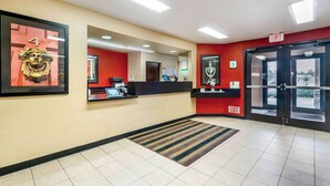 Un espace d’accueil d’hôtel comprenant un comptoir, des œuvres d’art encadrées et une porte de sortie.