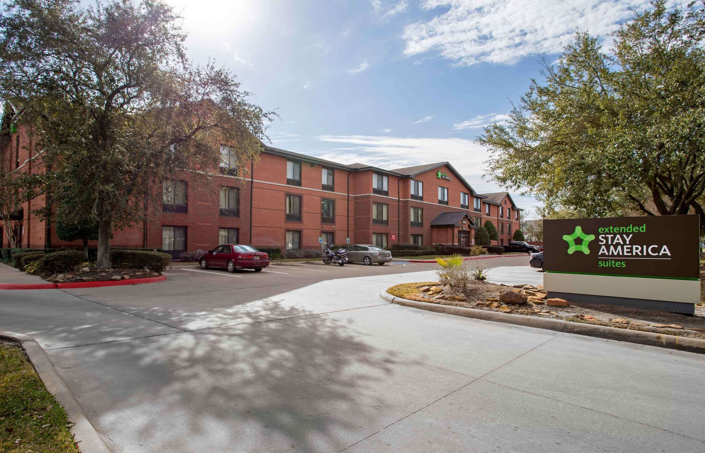 Un hotel Stay America Extended Suites con fachada de ladrillo, múltiples ventanas y un letrero.