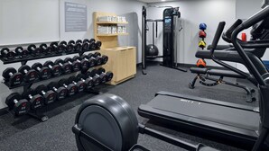 A fitness center with dumbbells, a treadmill, a weight machine, and exercise balls. - Spark by Hilton Dallas Medical District Love Field (Dallas)