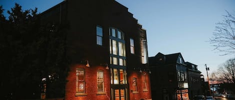 A brick building with large windows and a prominent entrance.