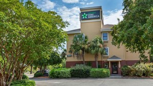 A Stay America hotel with a beige exterior, palm trees, and a parking lot. - Extended Stay America Suites Wilmington New Centre Drive (Wilmington)