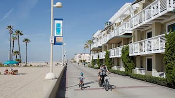 Un hôtel en bord de mer doté de balcons, offrant une vue sur la plage et un ciel dégagé.