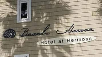Cartell per a 'Beach House Hotel at Hermosa' amb un logotip decoratiu de closca.