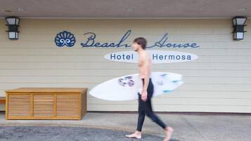 Un hôtel appelé « Beach House », avec un banc en bois devant l’entrée.