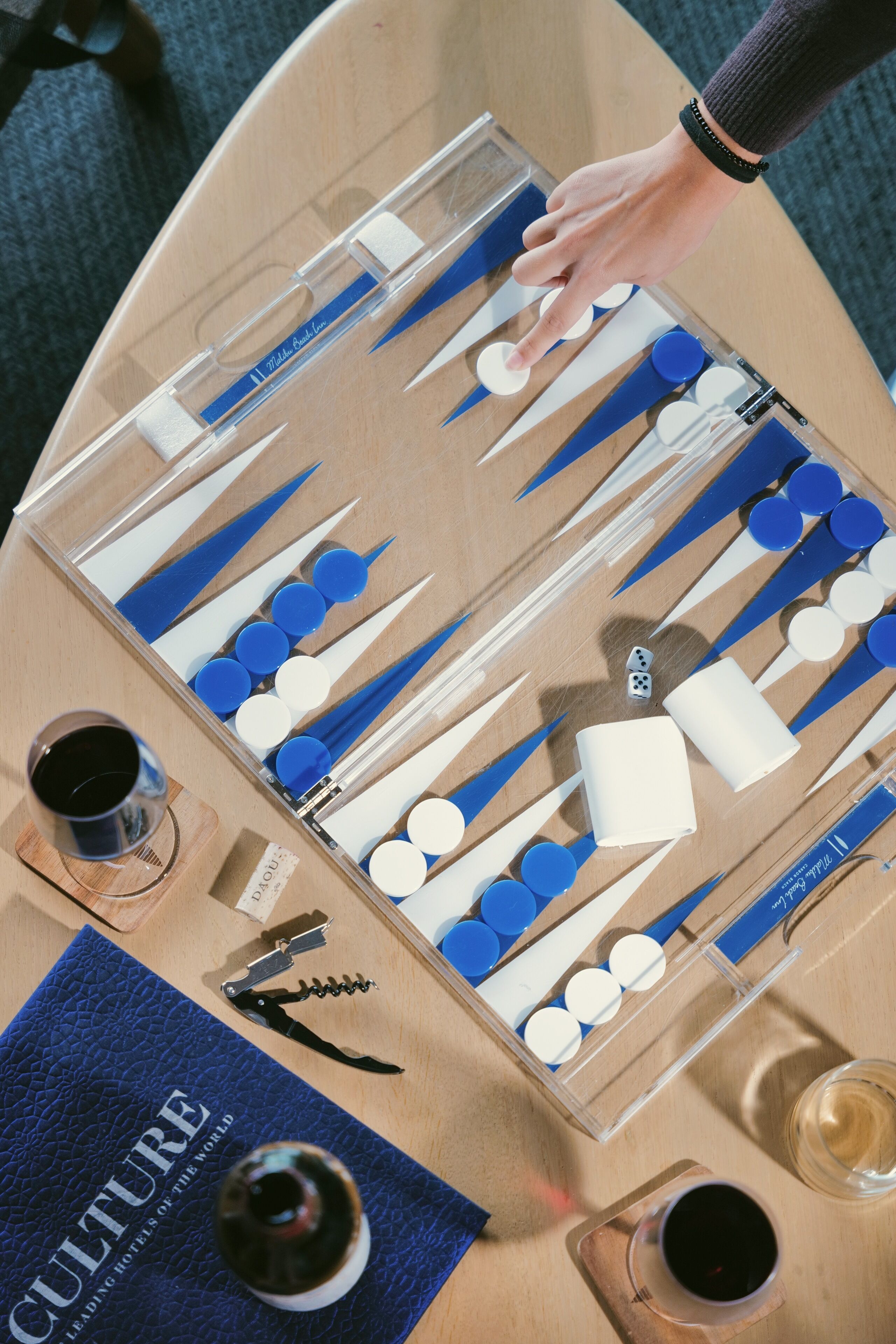 Preparación de un juego de mesa con varias piezas y una mano interactuando con él.