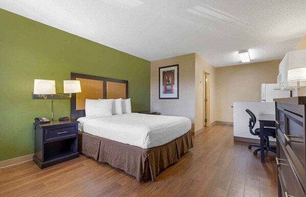 A hotel room with a bed, bedside tables, a desk, and a chair.