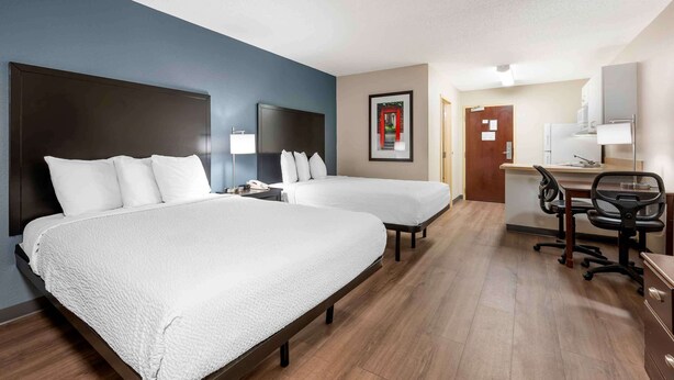 A hotel room with two beds, a desk, a chair, and a bathroom. - Extended Stay America Suites Fort Wayne South (Fort Wayne)