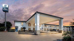 A Best Western hotel with a covered parking area, multiple stories, and a clear sky. - Best Western George West Executive Inn (George West)