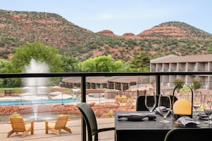 Una mesa de comedor con vista a una piscina y montañas.