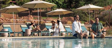 Un espace aménagé au bord de la piscine, avec des chaises longues et des parasols.