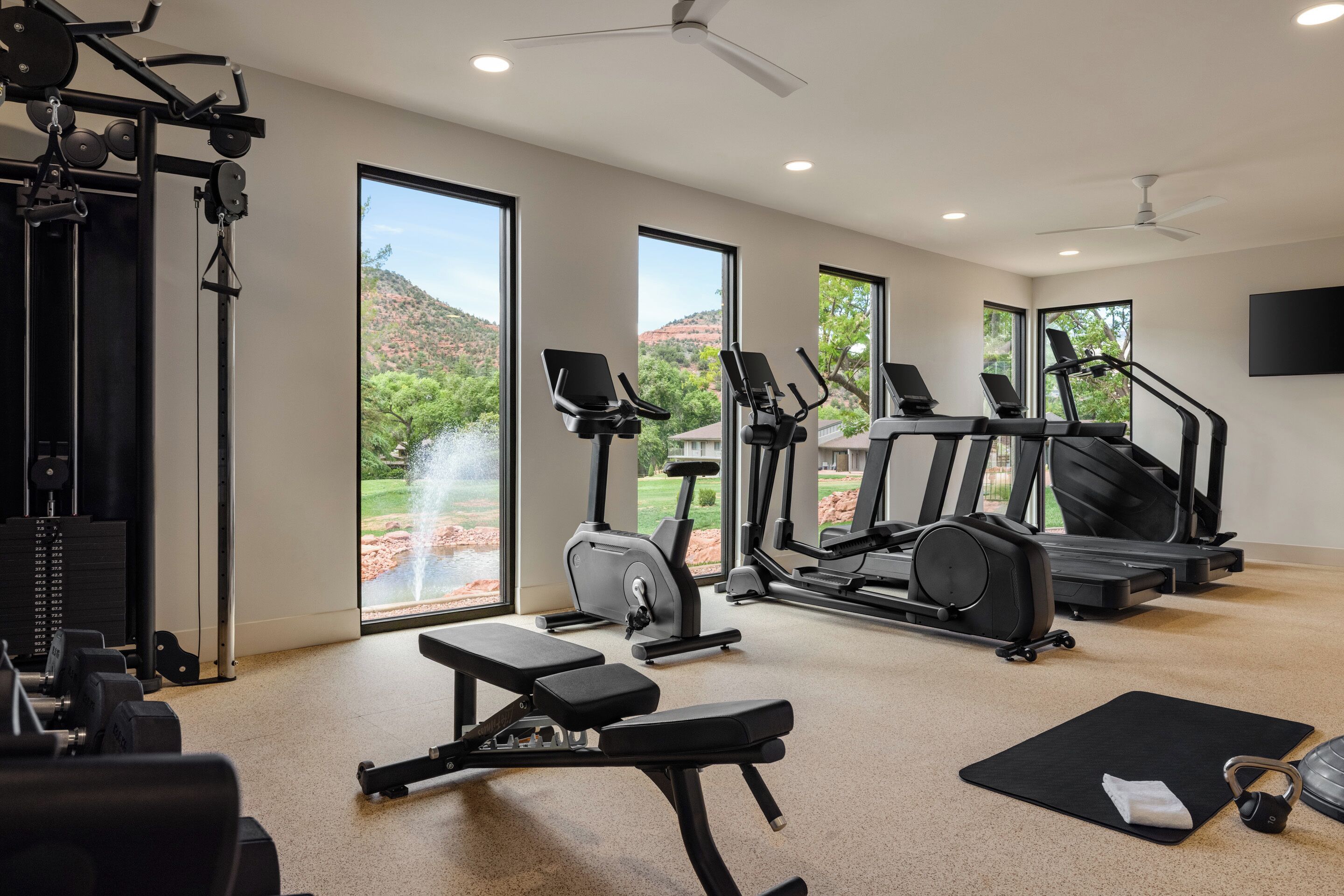 Uma academia em casa com equipamentos de ginástica, um banco e um tapete de yoga.