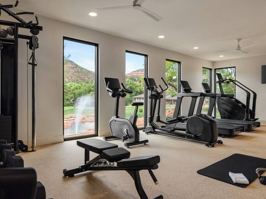 A home gym with exercise equipment, a bench, and a yoga mat.