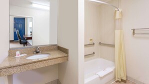 A bathroom with a granite countertop sink, a mirror, a bathtub, and a shower curtain. - Days Inn by Wyndham Reidsville (Reidsville)