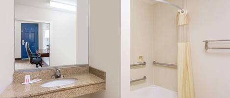 A bathroom with a granite countertop sink, a mirror, a bathtub, and a shower curtain.