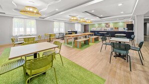 Un ambiente moderno con zona pranzo, cucina e posti a sedere.