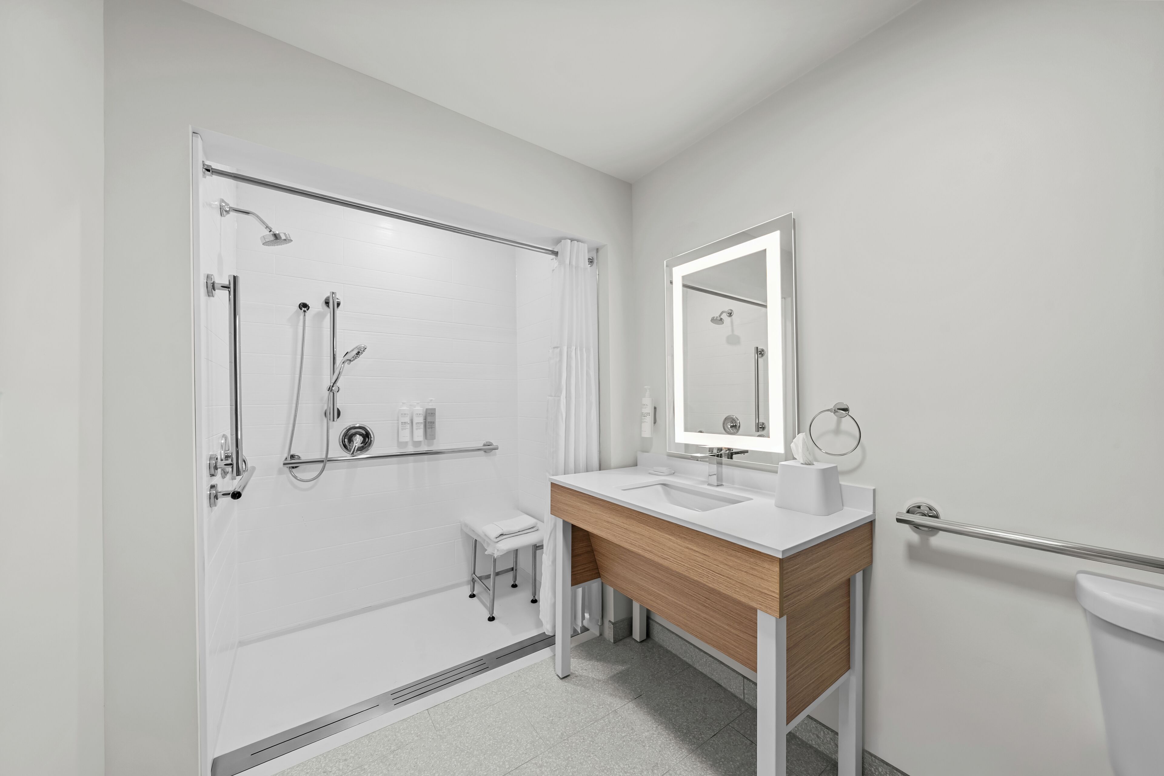 Une salle de bain moderne équipée d’une douche, d’un lavabo, d’un miroir et de toilettes.