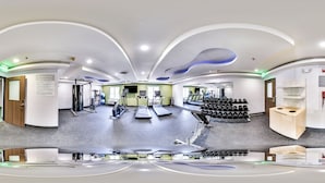 A gym with exercise equipment, treadmills, and a wall of dumbbells. - Spark by Hilton Milford Boston (Milford)