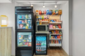 A vending machine area with snacks, beverages, and a microwave. - Spark by Hilton Milford Boston (Milford)