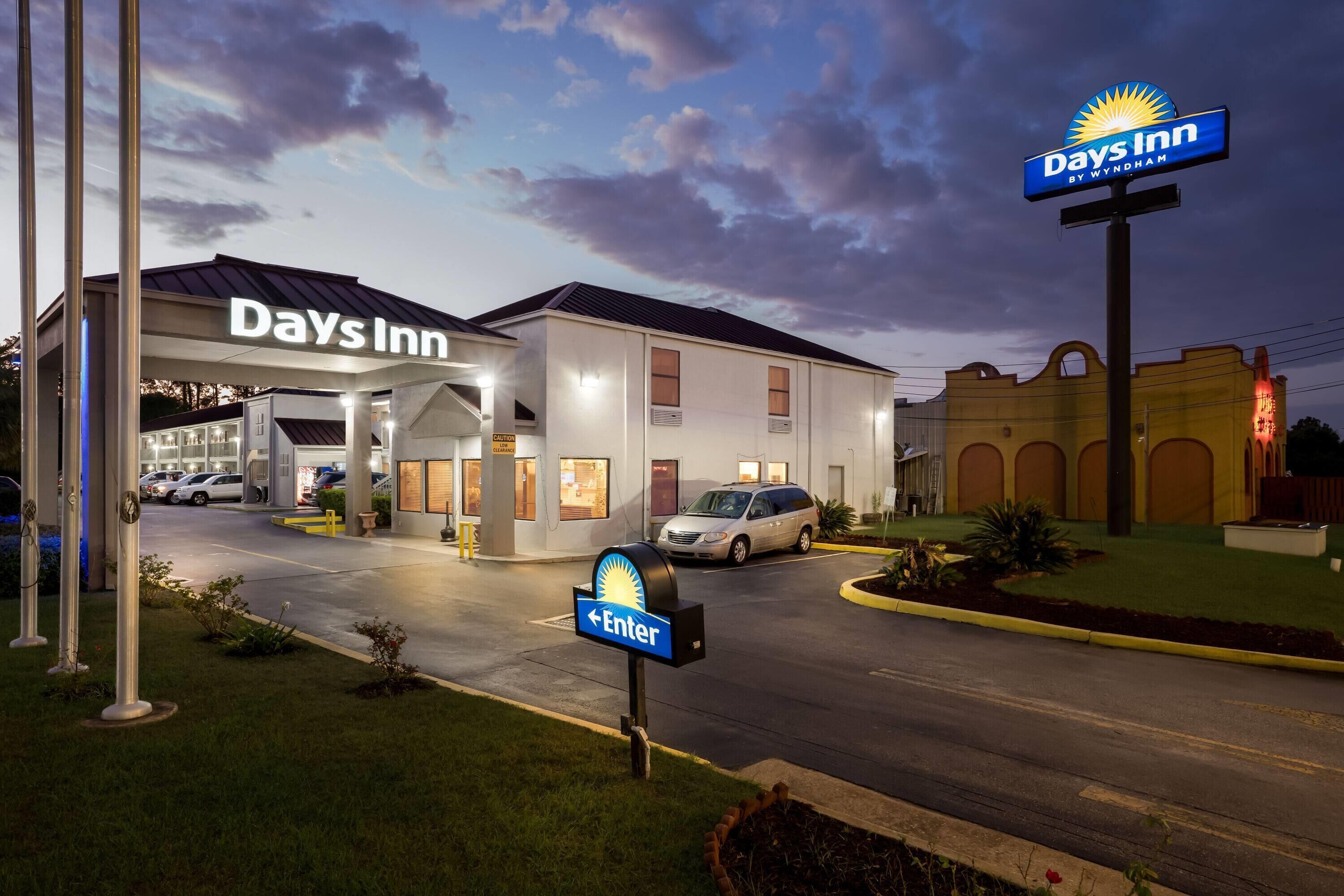 A Days Inn by Wyndham with a gas station, parking, and a sign indicating the entrance.
