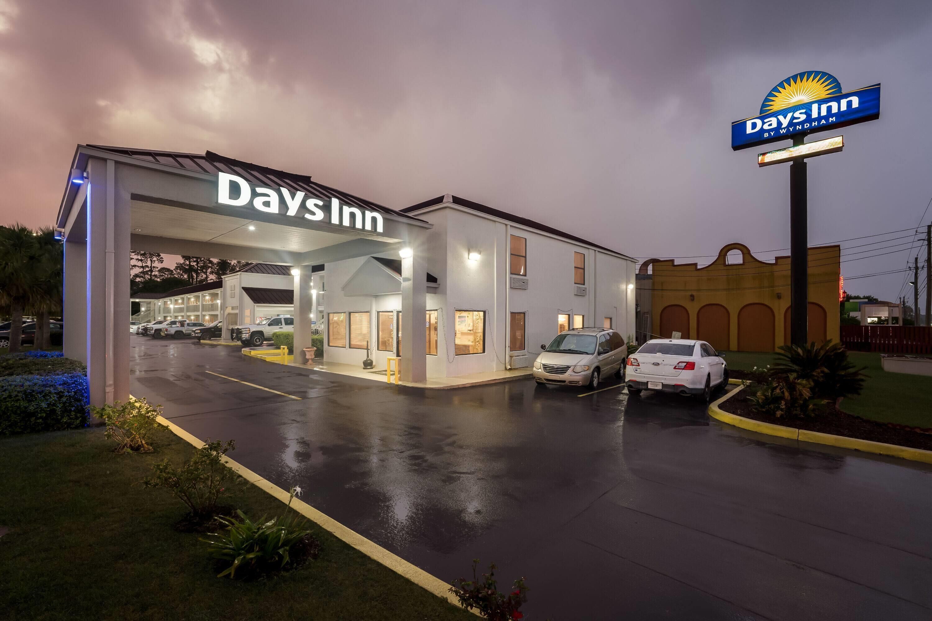 Un hotel Days Inn con zona de estacionamiento techada y señalización visible.