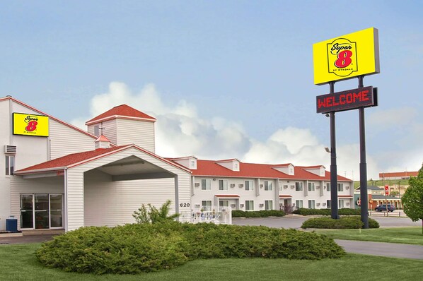 A motel with a red roof, a 'Super 8' sign, and a 'WELCOME' sign.