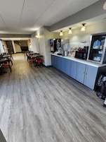 Un café avec un comptoir, un espace pour s’asseoir et un four à micro-ondes.