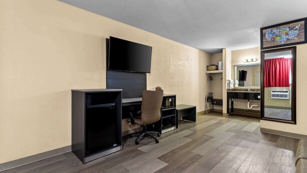 A room with a flat-screen TV mounted on the wall, a desk with a chair, a small shelf, and a mirror. - Econo Lodge Inn & Suites Santa Rosa (Santa Rosa)