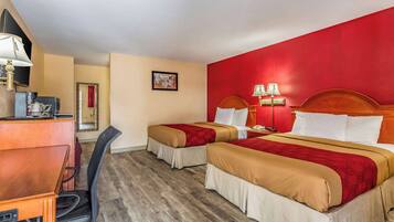 A hotel room with two beds, a desk, and a chair.