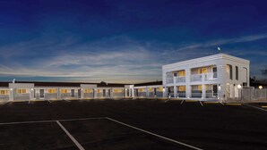 A hotel with a central building and multiple wings, featuring a large parking lot and a clear sky. - Econo Lodge Inn & Suites Santa Rosa (Santa Rosa)