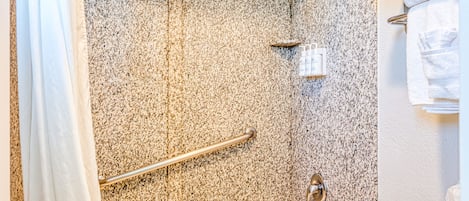 A bathroom with a bathtub, shower, and toilet.