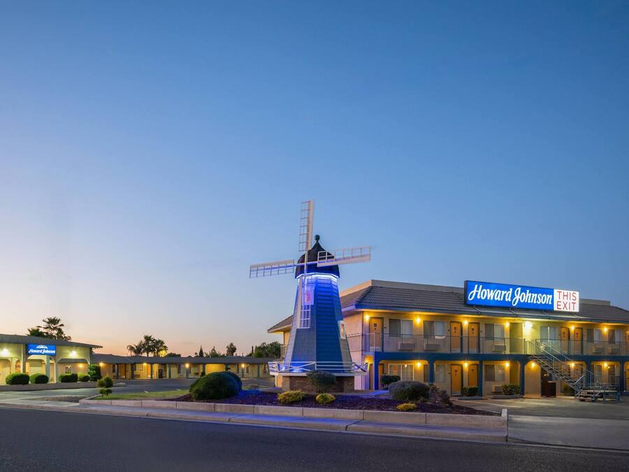 Un motel Howard Johnson con un molino, un letrero que indica la salida y una entrada bien iluminada.