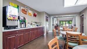 A modern kitchen area with a coffee machine, a refrigerator, and a buffet counter. - Quality Inn & Suites Canton, GA (Canton)