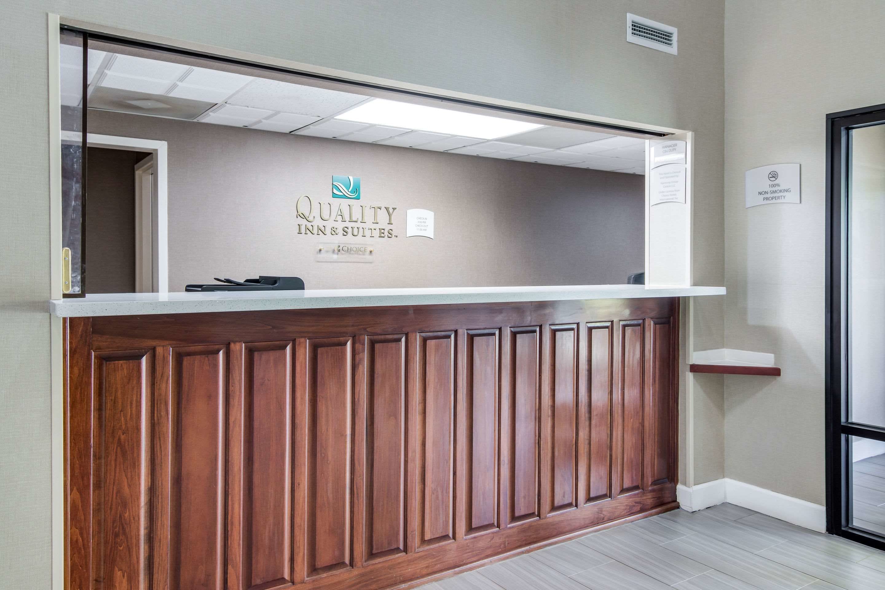 Een receptiebalie met een bord waarop 'Quality Inn & Suites' staat.