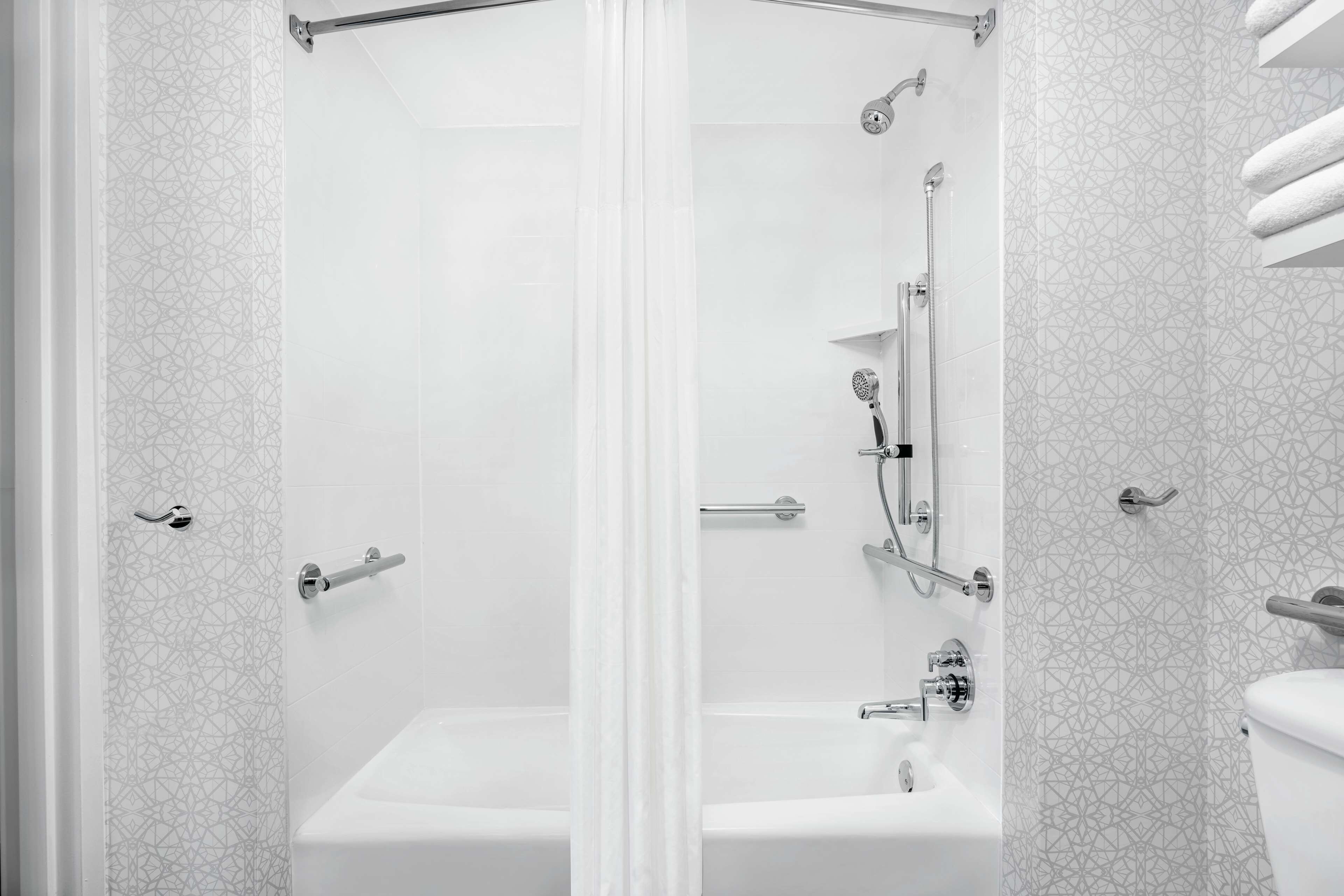 A modern bathroom with a walk-in shower, a bathtub, and a toilet.