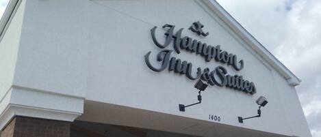 The exterior of Hampton Inn & Suites with a clear sky in the background.