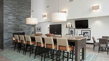 A modern dining area with a large rectangular table, multiple chairs, and a fireplace.