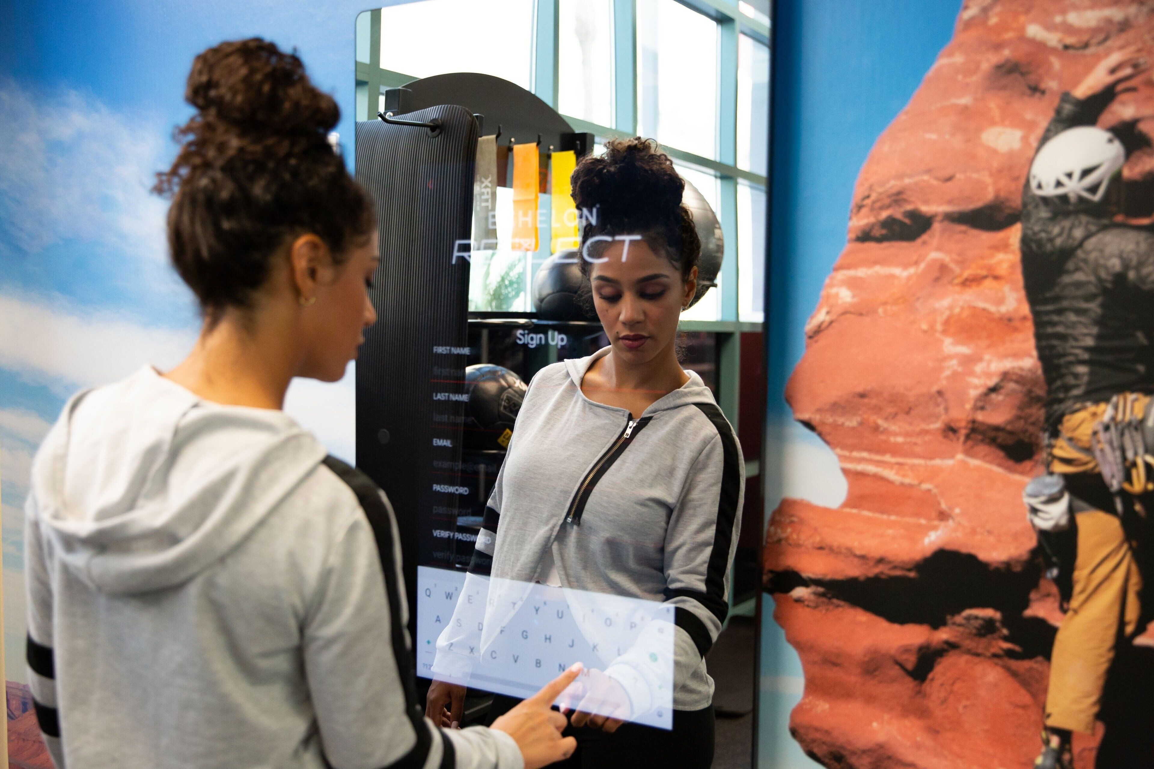 A person standing at a kiosk with a digital interface, possibly for signing up or checking information.