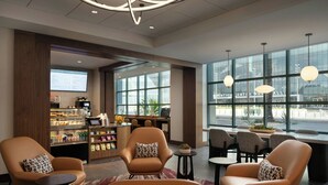 A modern lobby with leather armchairs, a coffee station, and large windows offering views of the city. - Las Vegas Marriott (Las Vegas)