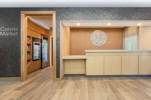 Una moderna zona de recepción con un mostrador de madera y un elemento decorativo en la pared.