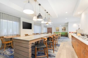 Un salón de conferencias con una larga mesa, varias sillas e iluminación colgante.
