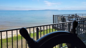 Un balcon avec vue sur la mer et une île lointaine.