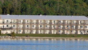 Un grand hôtel à plusieurs étages, doté de nombreux balcons, situé au bord d’un lac.