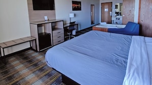 Une chambre d’hôtel équipée d’un lit, d’un bureau, d’une chaise et d’un petit coin salon.