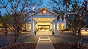 A hotel entrance with a covered walkway, potted plants, and a clear view of the building's entrance. - Hilton Garden Inn Tallahassee (Tallahassee)