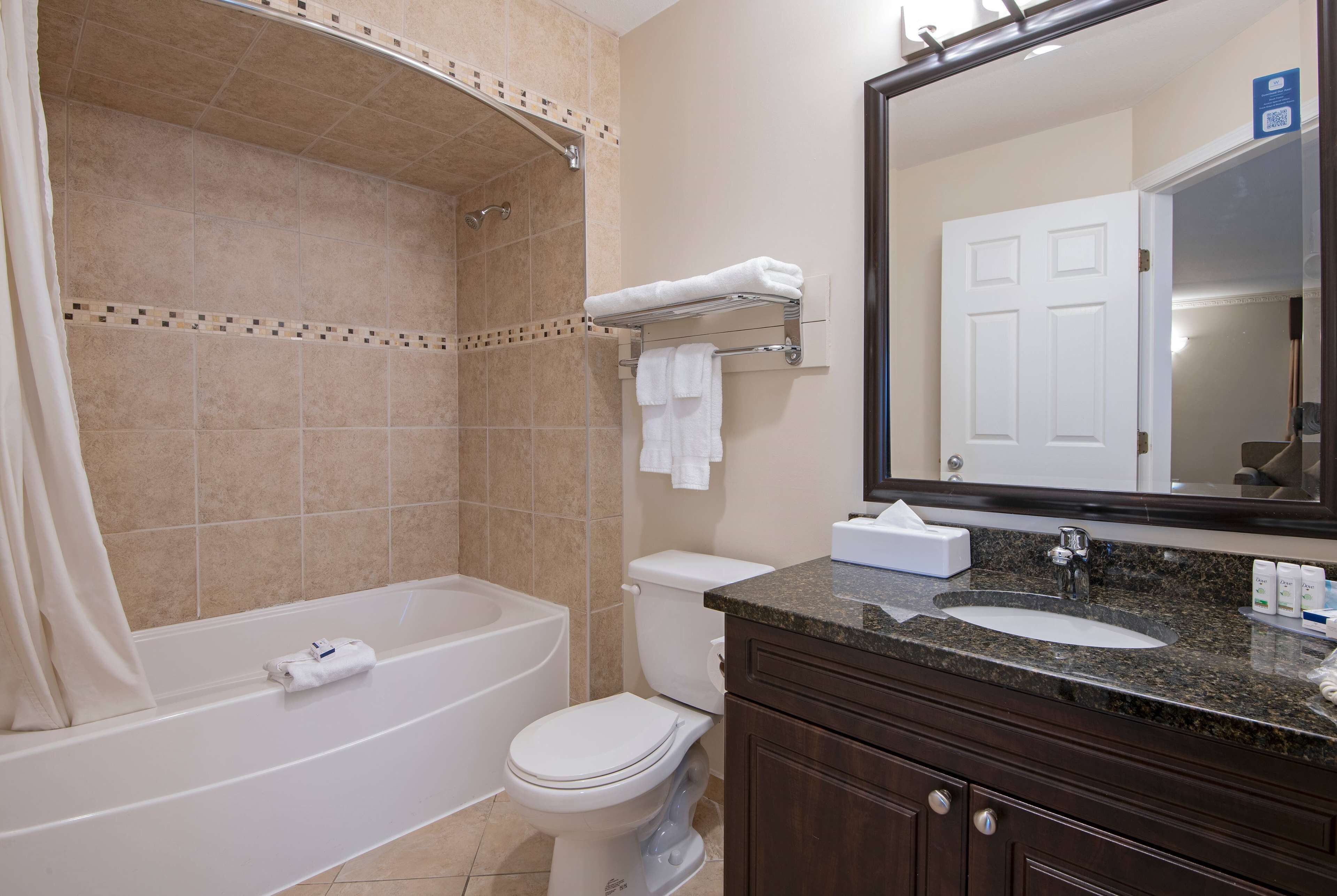 A bathroom with a bathtub, toilet, and sink.